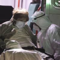 Medical staff evacuate an elderly patient from a nursing home after multiple residents of the facility tested positive for the new coronavirus in Buenos Aires on Tuesday. | AP