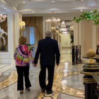 Julius and Sarah Wishnia, who have been married for 70 years, walk in the lobby of The Palace, an upscale retirement community in Coral Gables, Florida. | REUTERS
