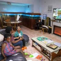 Amid the spread of the coronavirus disease, a family watches television inside their apartment in Kinshasa, Democratic Republic of Congo, on Saturday. | REUTERS