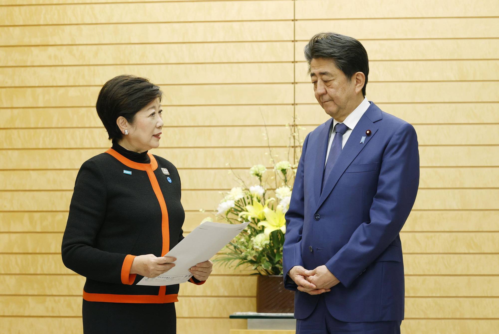 Tokyo Gov. Yuriko Koike submits requests regarding the COVID-19 outbreak control to Prime Minister Shinzo Abe at his office in Tokyo on March 26. | KYODO