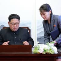 North Korean leader Kim Jong Un signs a guestbook next to his sister Kim Yo Jong inside the Peace House at the border village of Panmunjom in the Demilitarized Zone on April 27, 2018. | KOREA SUMMIT PRESS POOL / VIA AP