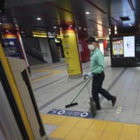 A worker cleans an empty platform at a subway station in Tokyo on Thursday. | AP