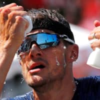 Jan Frodeno, of Germany, tries to cool down during the Ironman Triathlon European Championships in Frankfurt, Germany, on June 30, 2019. Frodeno won the event. | REUTERS