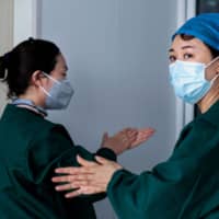 Medical personnel working on nucleic acid testing as part of COVID-19 pandemic measures, work at a health services center in Suifenhe, China, on Friday. | AFP-JIJI