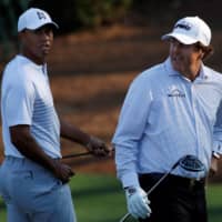 Tiger Woods (left) and Phil Mickelson walk to the 11th tee during the second day of practice for the Masters on April 3, 2018, in Augusta, Georgia. | REUTERS