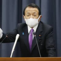Finance Minister Taro Aso speaks at a news conference in Tokyo on Monday. | KYODO