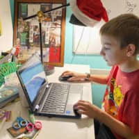 Eli Illig, 10, studies his computer at home in Ebensburg, Pa. The frustration of parents is mounting as more families across the U.S. enter their second or even third week of total distance learning.  | KARA ILLIG VIA AP