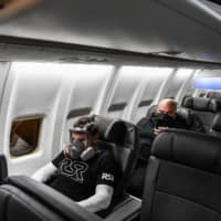 A man wears a gas mask as he takes a flight from Miami to Atlanta on Thursday.  | AFP-JIJI
