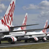 Grounded Virgin Australia aircraft are parked at Brisbane Airport in Brisbane, Australia.  | AAP IMAGE / VIA AP
