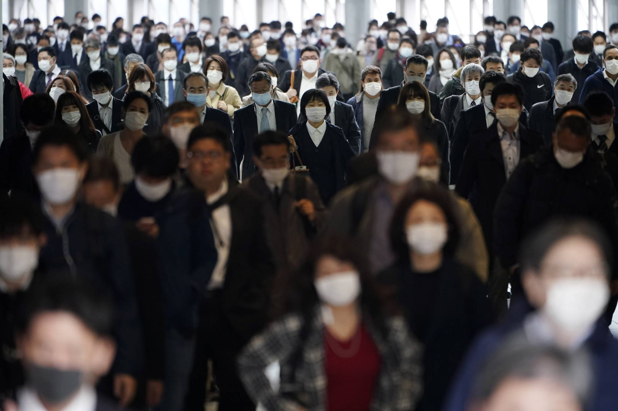 A Tokyo train station passageway is crowded with commuters during rush hour on Monday. | AP