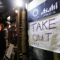 A sign promoting takeouts is seen outside an izakaya restaurant in Tokyo\'s Yurakucho district on April 3. | KYODO