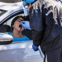 A woman gets tested for the coronavirus in Minneapolis, Minnesota, on Monday. |  STAR TRIBUNE VIA AP