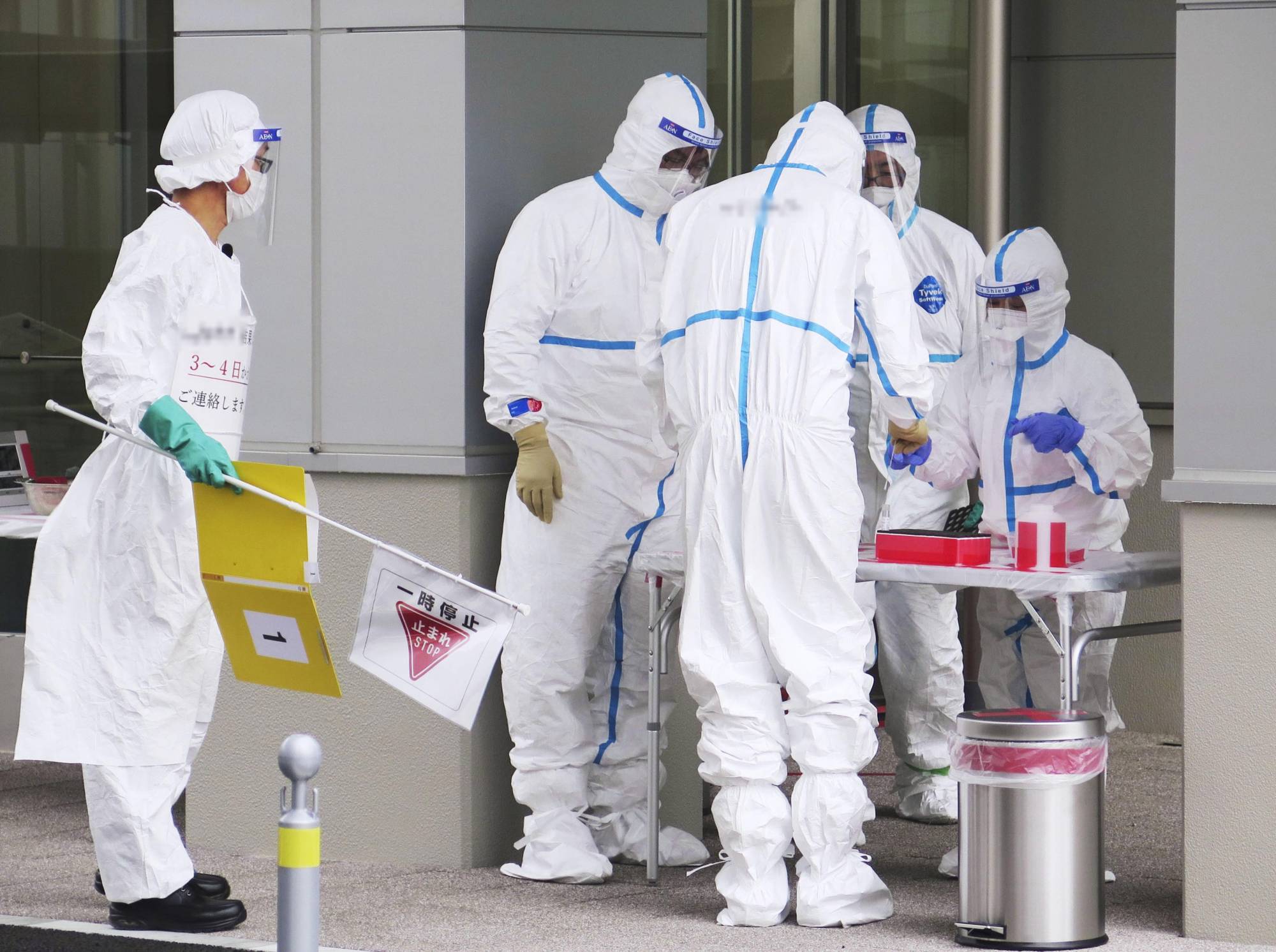 Doctors prepare for drive-through coronavirus testing on Monday in Koshigaya, Saitama Prefecture. Even after the state of emergency is lifted in Japan, experts agree that more testing will be crucial to permanently contain the virus. | KYODO