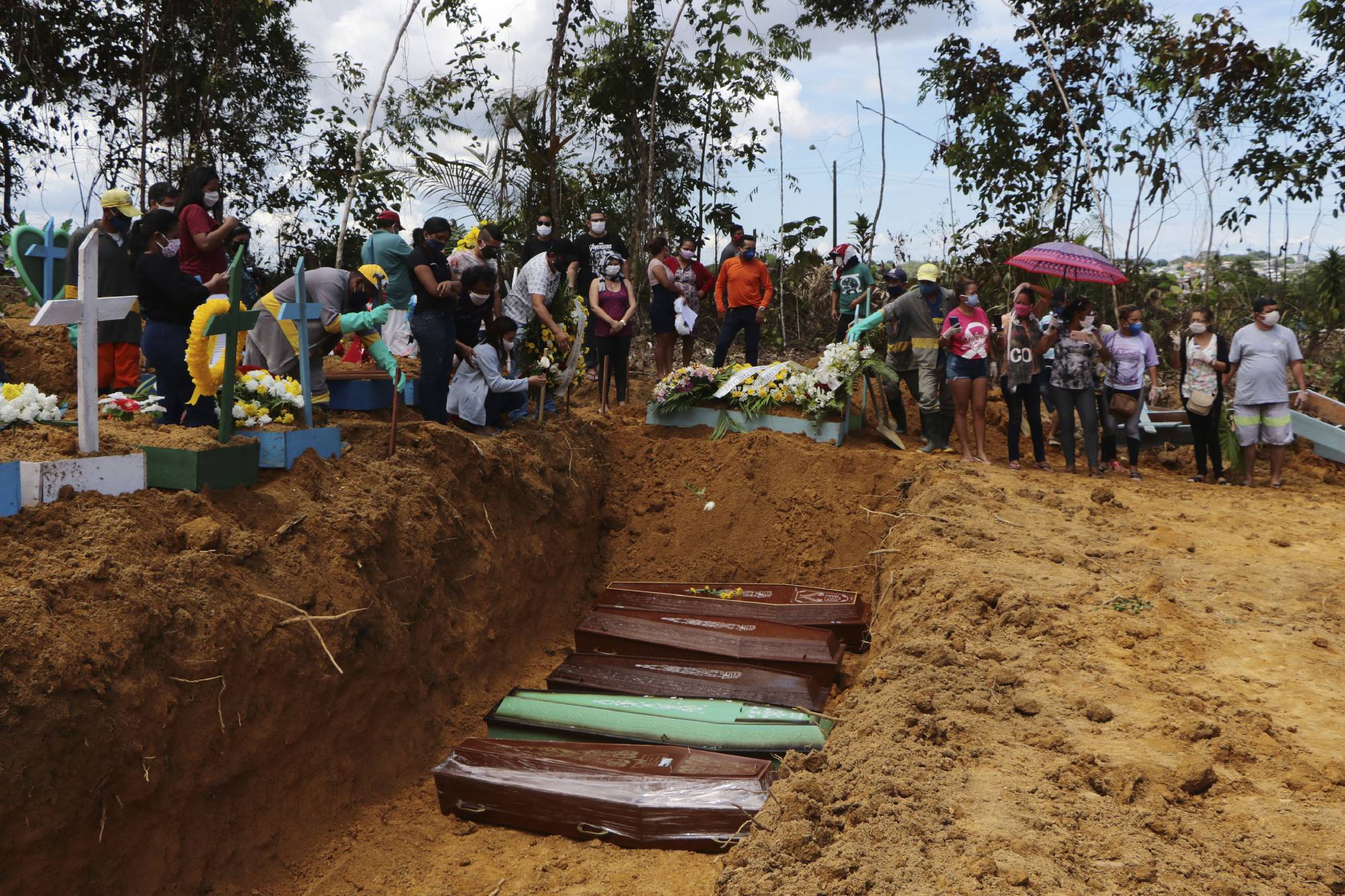 Relatives mourn at the site of a mass burial at the Nossa Senhora Aparecida cemetery, in Manaus, Amazonas state, Brazil, on April 21. The cemetery is carrying out burials in common graves due to the large number of deaths from COVID-19 disease. | AP