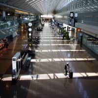 A few passengers walk through a domestic terminal at Haneda Airport in Tokyo, at the start of Golden Week holiday on Wednesday. | AP