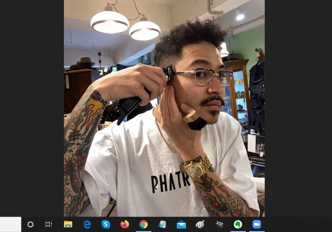 Saito Kon, a barber at Mr. Brothers Cut Club in Harajuku, demonstrates how he teaches customers how to cut their own hair using video conferencing app Zoom. | TOMOHIRO OSAKI