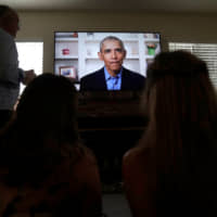Torrey Pines High School graduating student Phoebe Seip, 18 (right), her father, Jake, 57, and her sister, Sydney, 22, watch former U.S. President Barack Obama deliver a virtual commencement address to millions of high school seniors who will miss graduation ceremonies due to the coronavirus pandemic, while celebrating Phoebe\'s canceled prom night at home in San Diego on Saturday. | REUTERS