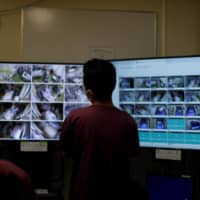 A medical worker monitors live footage of patients in the intensive care unit for COVID-19 in St. Marianna Medical University Hospital in Kawasaki on Monday. | REUTERS