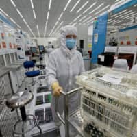 A technician pushes a cart loaded with 300mm silicon wafers at the Applied Materials Inc. Maydan Technology Center in Santa Clara, California. | BLOOMBERG