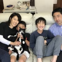 A real family: The Sugiura boys are delighted with their new cat, Rapi. Naohiro holds her while Kimiyasu waits for a turn to pet her.  | AYAKO SUGIURA

