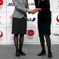 An All Nippon Airways (left) and Japan Airlines cabin attendant hands at Tokyo 2020 Olympic and Paralympic Games Official Partner ceremony in Tokyo in June 2015. ` | REUTERS