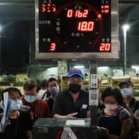 Buyers wearing face masks attend an auction of fruits and vegetables at a wholesale market in Taipei, on Thursday. The leaders of U.S. congressional foreign affairs committees have written to more than 50 countries asking them to support Taiwan\'s inclusion in the World Health Organization, citing the need for the broadest effort possible to fight the coronavirus pandemic. | REUTERS
