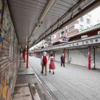 People walk past shuttered stores in Tokyo\'s Asakusa tourist area on Saturday amid an extended nationwide state of emergency over the coronavirus pandemic. | KYODO