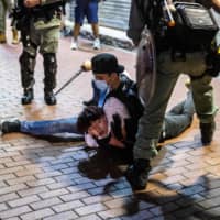 A pro-democracy demonstrator is held on the ground before being arrested by undercover police during a protest calling for the Hong Kong\'s independence in the Mong Kok district on Sunday.  | AFP-JIJI
