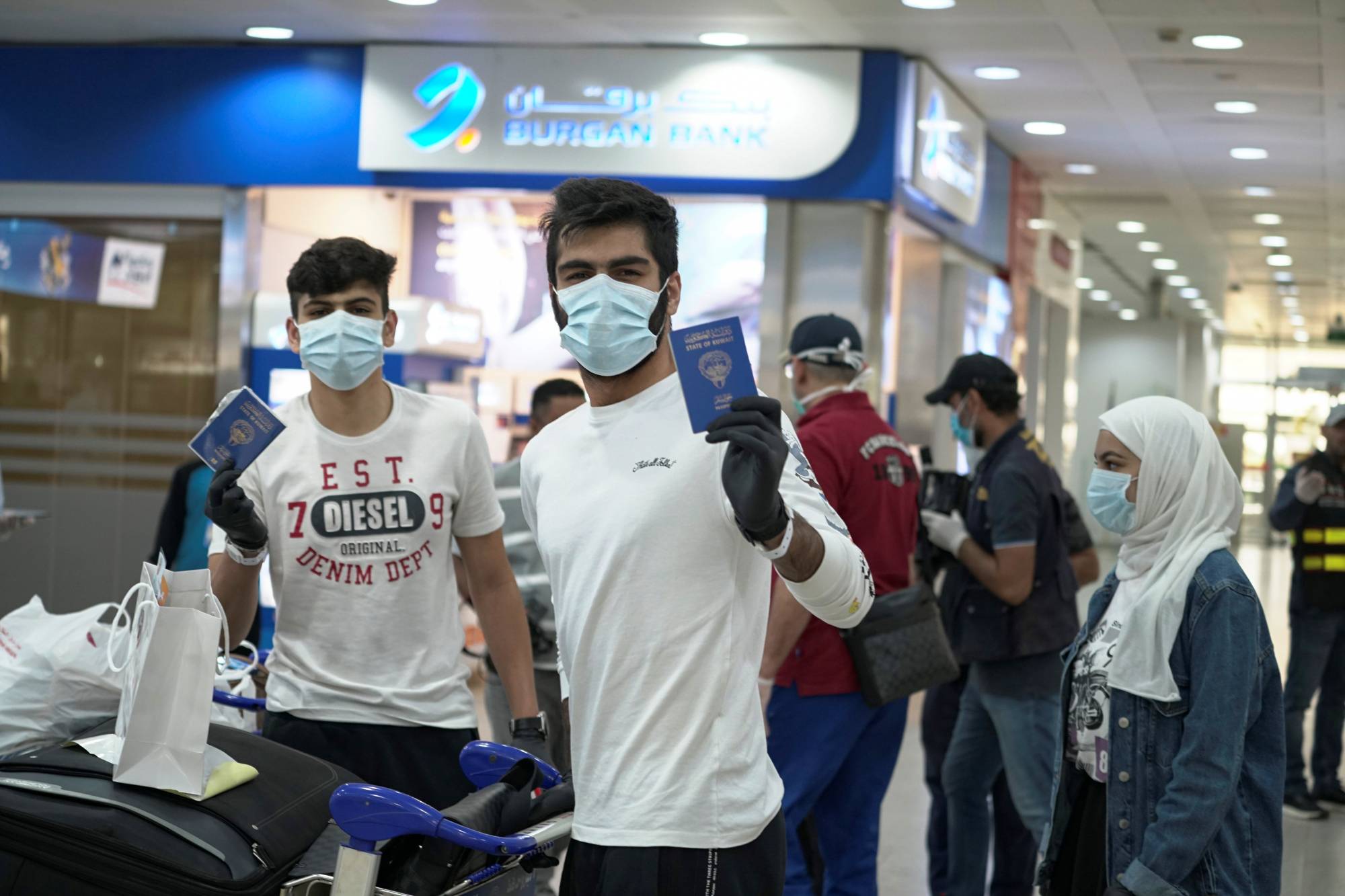 Right of passage: Young Kuwaitis arrive home from Jordan wearing face masks and quarantine tracking bracelets. | REUTERS