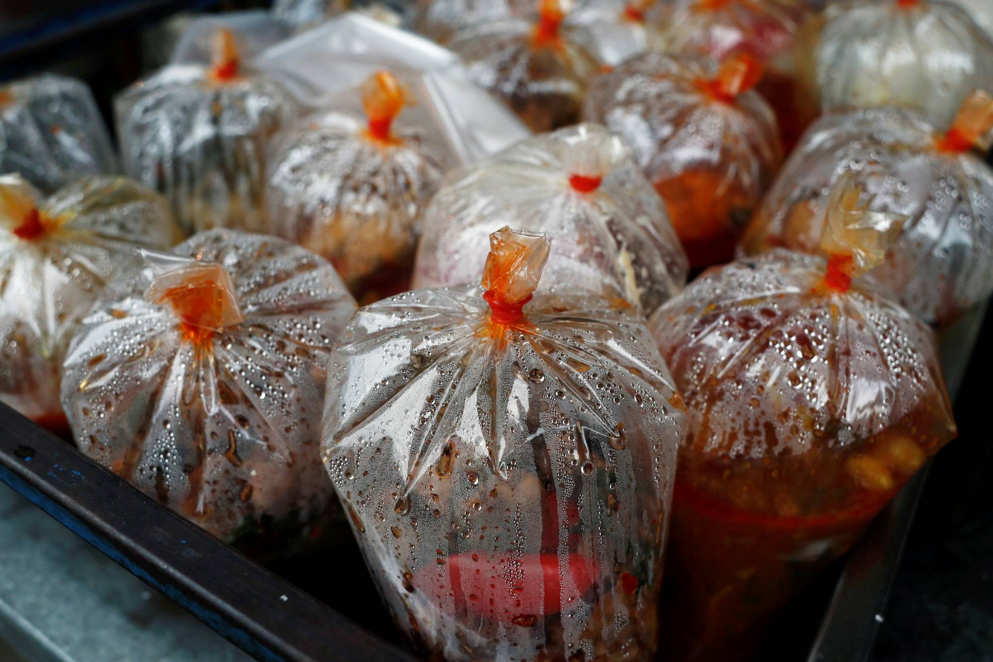 Plastic bags filled with food are displayed for sale in a market in Bangkok on Monday. Plastic waste in the Thai capital soared 62 percent in volume in April amid the coronavirus pandemic.  | REUTERS