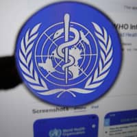 The logo for the World Health Organization WHO Info application is displayed on a computer screen. | BLOOMBERG