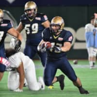 Obic Seagulls running back Asaki Mochizuki (center) carries the ball against IBM BigBlue during the Pearl Bowl final on June 28, 2018, at Tokyo Dome. The annual tournament was canceled this spring due to the COVID-19 outbreak. | HIROSHI IKEZAWA
