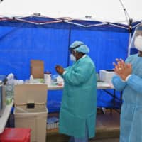 Health care workers wait for patients at the Brightpoint Health and UJA Federation for NY free pop-up coronavirus testing site on May 8 in the Brooklyn borough of New York City. | AFP-JIJI