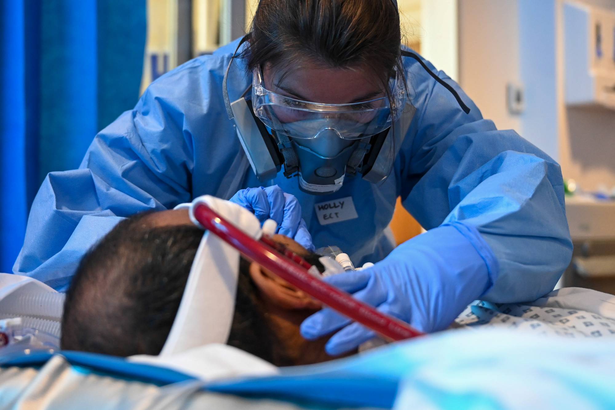 A medical worker cares for a patient at a hospital in Cambridge, England. Beating the initial sickness may be just the first of many battles for those who survive COVID-19.  | BLOOMBERG