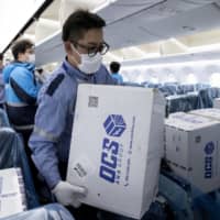 Boxes containing masks and other medical supplies are unloaded April 22 at Tokyo\'s Haneda Airport. The coronavirus pandemic has highlighted Japan\'s dependence on imported products, particularly from China. | ALL NIPPON AIRWAYS / VIA AP