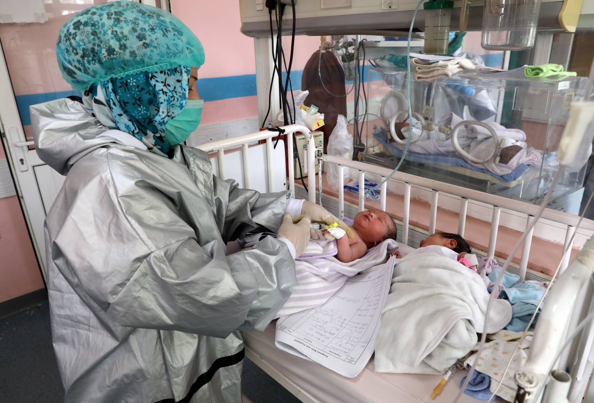 An Afghan nurse observes newborn children who lost their mothers during an attack at a hospital, in Kabul, on Wednesday. | REUTERS