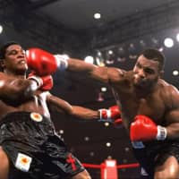 Mike Tyson (right) punches Trevor Berbick during their bout on Nov. 22, 1986, in Las Vegas. | AP