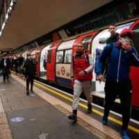 People step off a train at a subway station in London on Thursday. | REUTERS