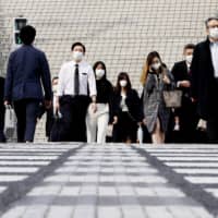 People walk by Nagoya Station in Aichi Prefecture while commuting on April 17.  | KYODO