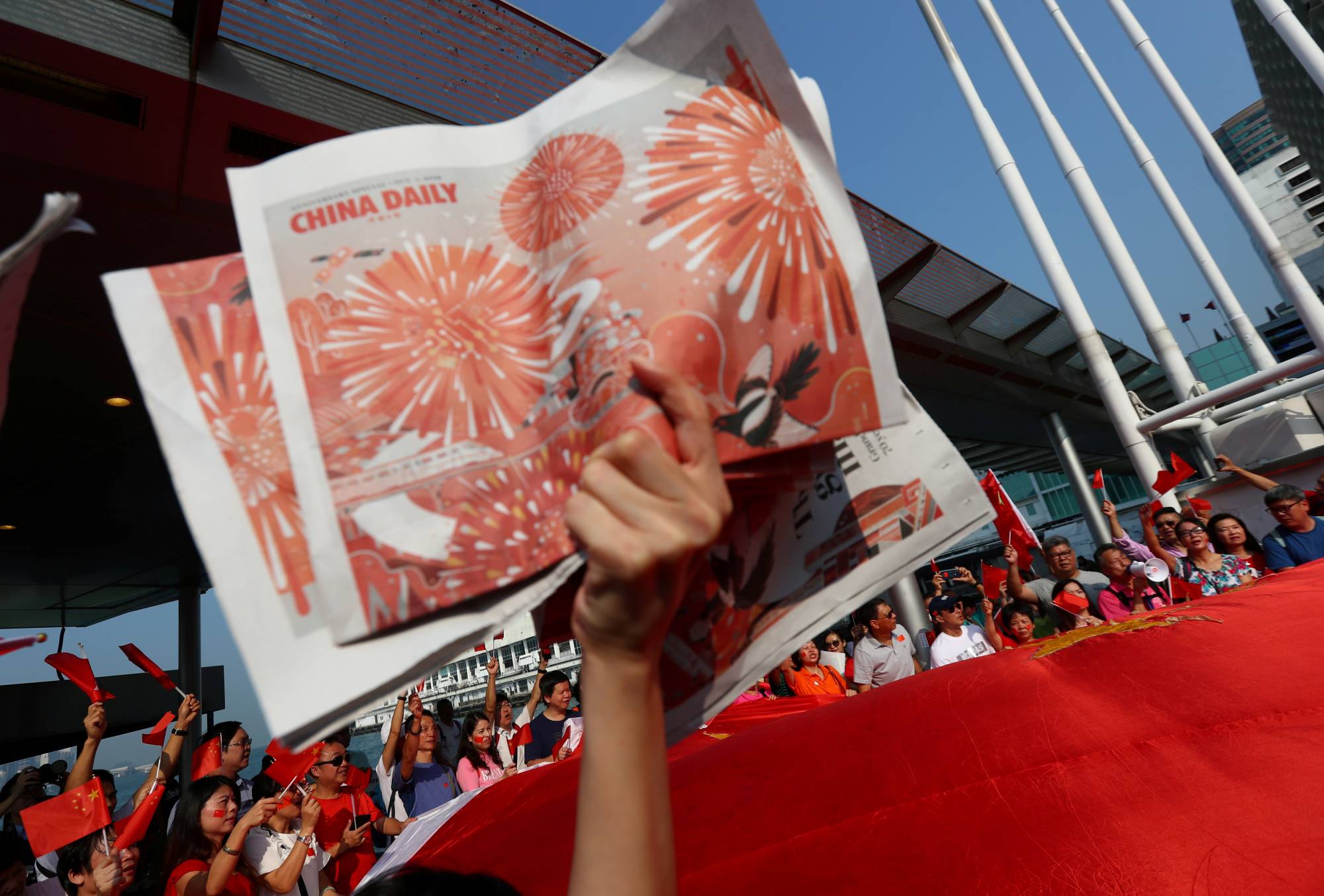 A China supporter holds up copies of the China Daily at Harbour City, Hong Kong, during China's National Day on Oct. 1 last year. | REUTERS 