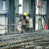 An employee works on steel bars at a factory in Hangzhou, in the Zhejiang province of China, on Friday. | AFP-JIJI