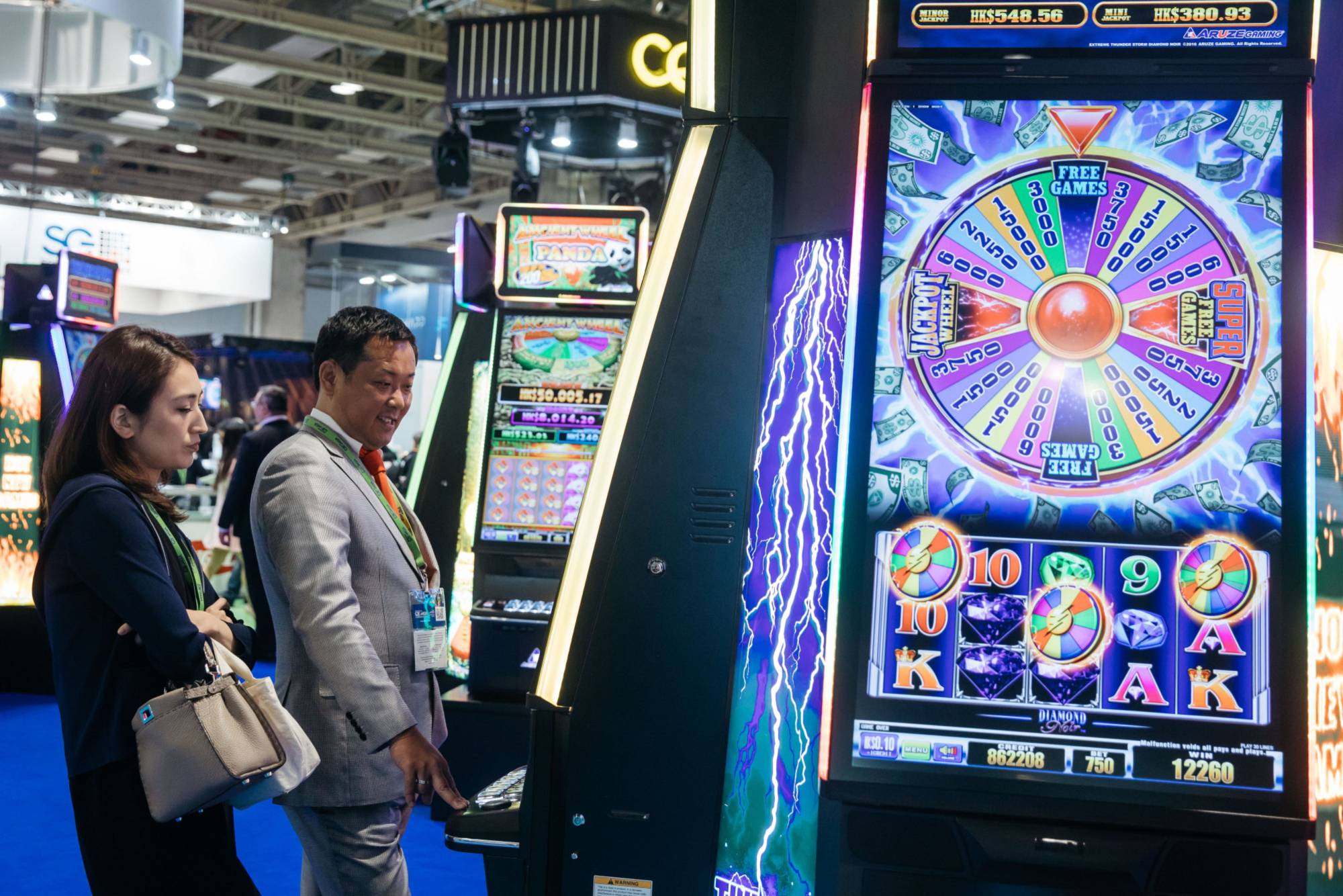 Customers play a slot machine at the Venetian Macao resort and casino, run by a unit of Las Vegas Sands Corp. in Macao. The company's withdrawal from its quest to win permission to build an integrated casino resort is a major setback in Japan’s efforts to introduce casinos. | BLOOMBERG