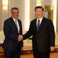World Health Organization Director-General Tedros Adhanom Ghebreyesus shakes hands with Chinese President Xi jinping before a meeting at the Great Hall of the People in Beijing on Jan. 28. | POOL / VIA REUTERS