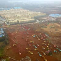 Excavators and bulldozers are seen at the construction site in Wuhan, China, where the new hospital was being built to treat patients of the new coronavirus, on Jan. 24. | CNS / VIA REUTERS