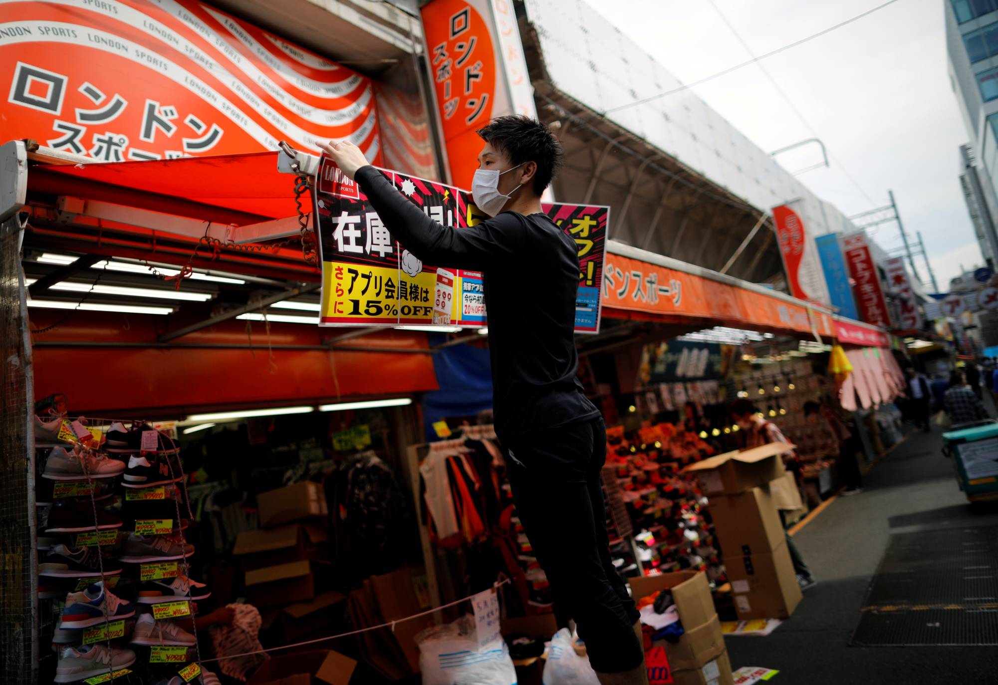 Back to business: An employee of a shoes shop prepares to reopen their business during the spread of COVID-19 in Tokyo. | REUTERS