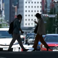 People walk on a street in Tokyo\'s Ginza shopping district on Sunday. | AFP-JIJI
