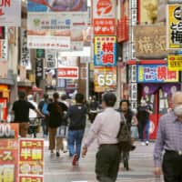 People stroll down a shopping street in Osaka City\'s Umeda district on Sunday. | KYODO 