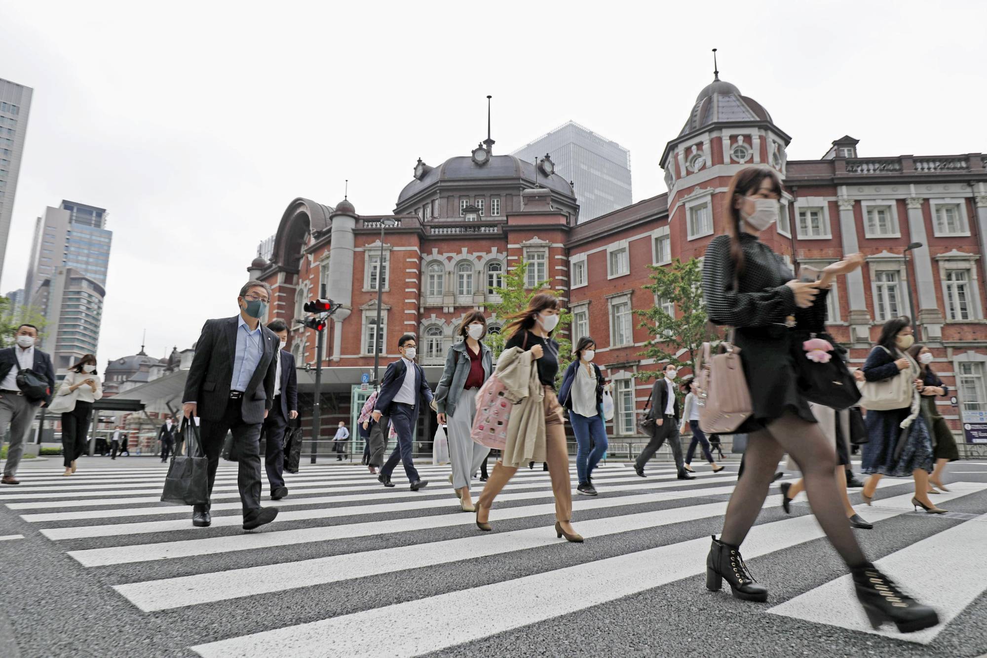 People going to work are seen outside the Tokyo Station on Monday. Japan's economy slipped into a recession in the three months through March. | KYODO