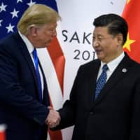 Chinese President Xi Jinping greets U.S. President Donald Trump before a bilateral meeting on the sidelines of the Group of 20 summit in Osaka last June. | AFP-JIJI