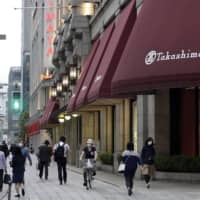 Pedestrians walk past a reopened Takashimaya Co. department store in the Nihonbashi district of Tokyo on Monday. | BLOOMBERG